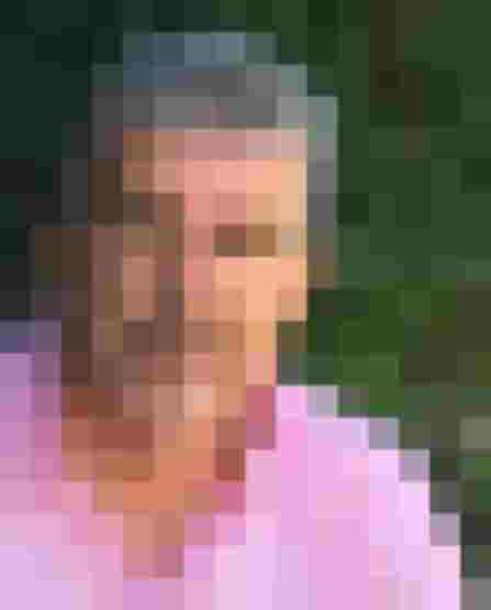 Kunstmaler mit grauem Haar, sitzt entspannt im Freien, umgeben von grünen Pflanzen.